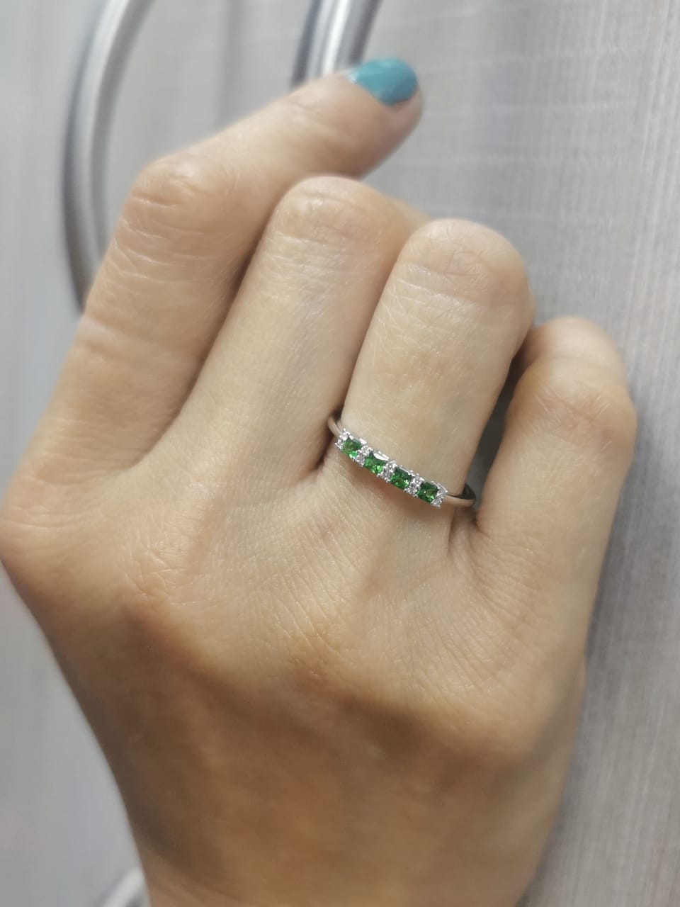18K white gold ring with square-cut tsavorites and alternating round diamonds in a half eternity band