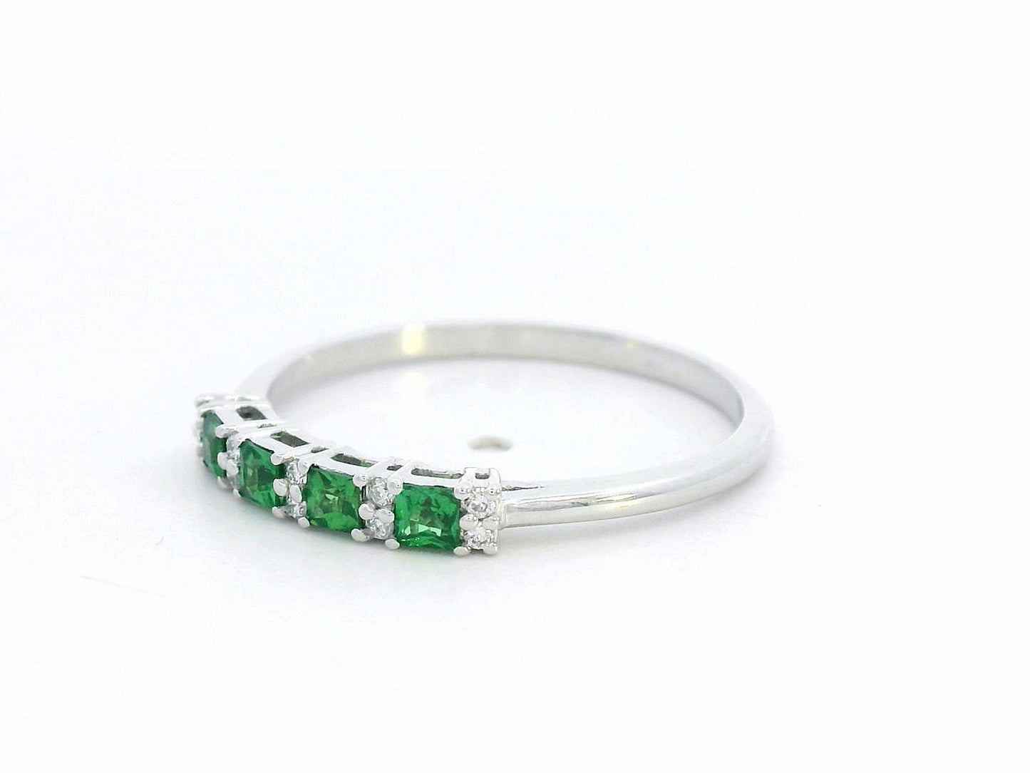 18K white gold ring with square-cut tsavorites and alternating round diamonds in a half eternity band