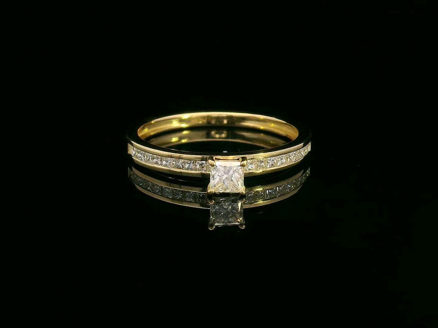 18K gold ring with a 0.24 carat princess-cut diamond and 0.27 carats of channel-set princess-cut diamonds on the band
