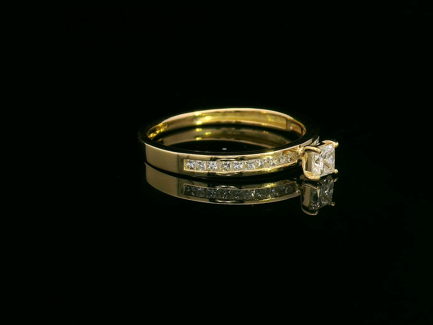 18K gold ring with a 0.24 carat princess-cut diamond and 0.27 carats of channel-set princess-cut diamonds on the band
