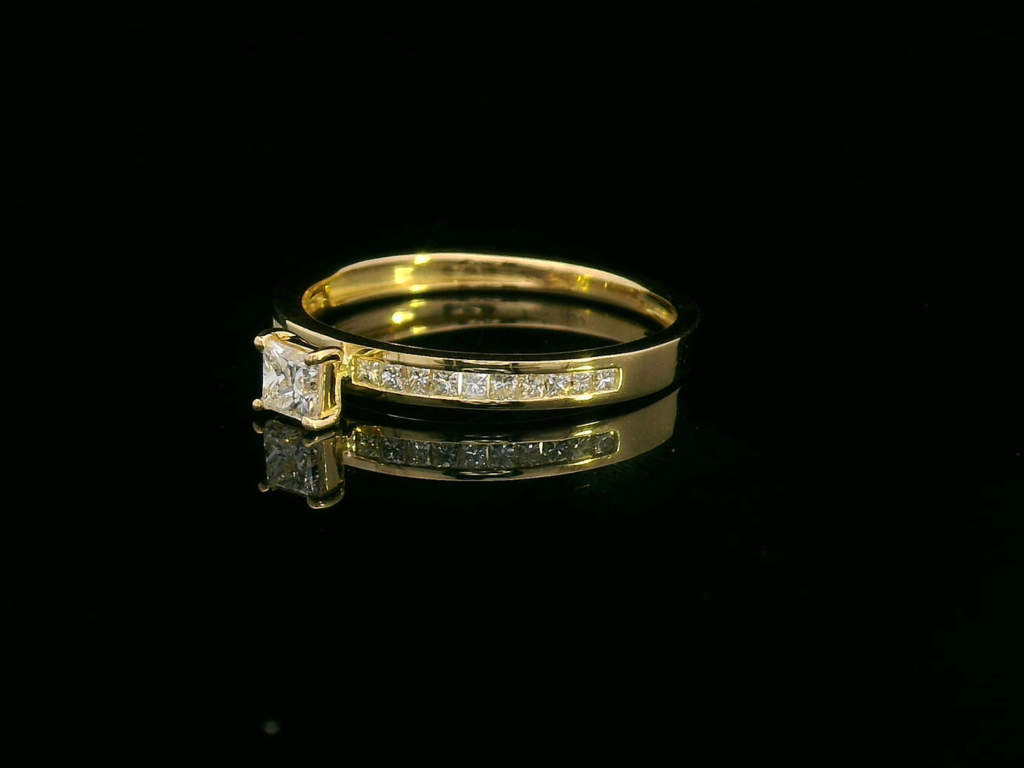 18K gold ring with a 0.24 carat princess-cut diamond and 0.27 carats of channel-set princess-cut diamonds on the band