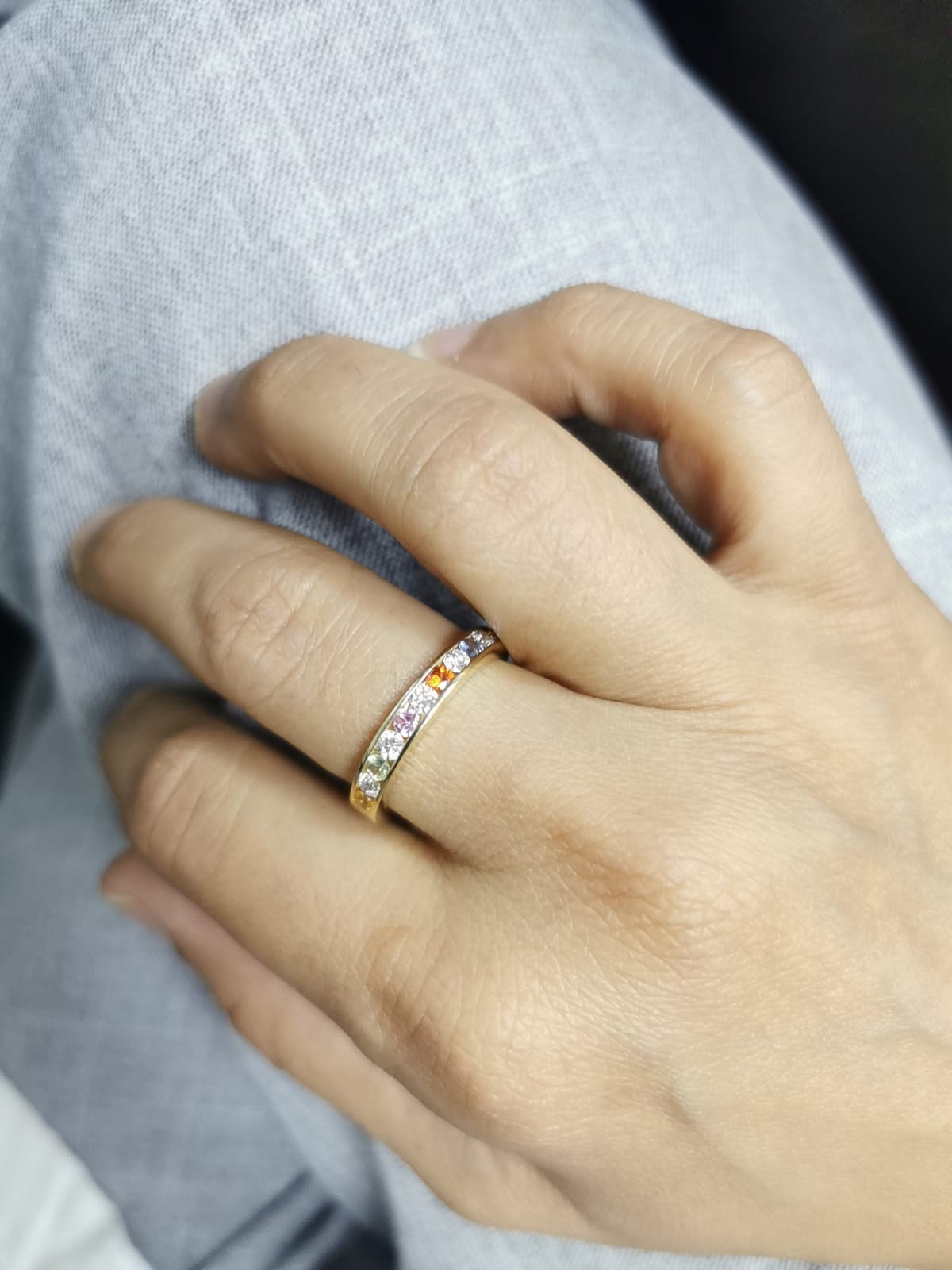 18K yellow gold band with alternating multi-color sapphires and round-cut diamonds in a channel setting