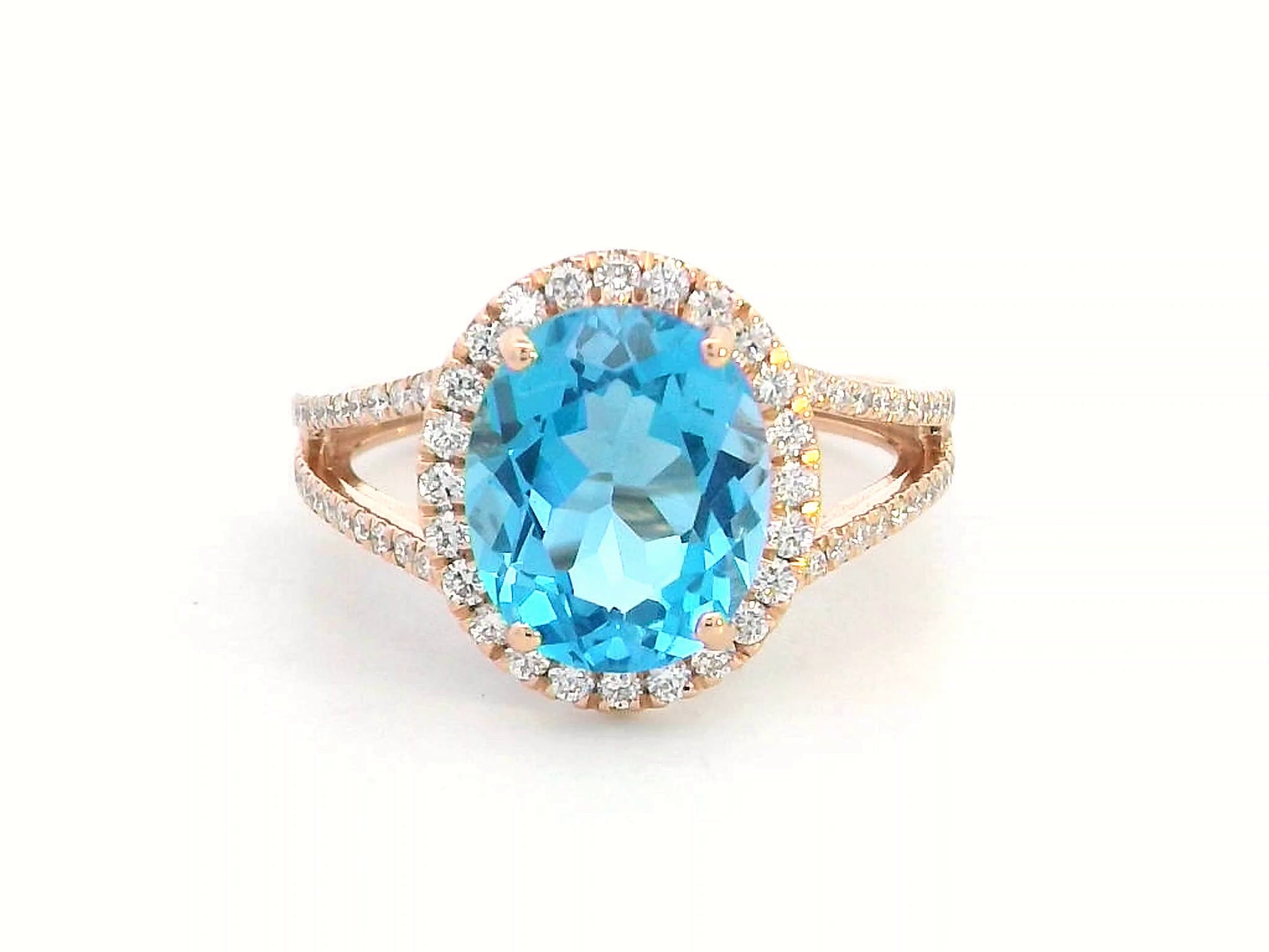 18K rose gold ring with a 4.54 carat oval Swiss Blue Topaz, diamond halo, and diamond-accented split shank design