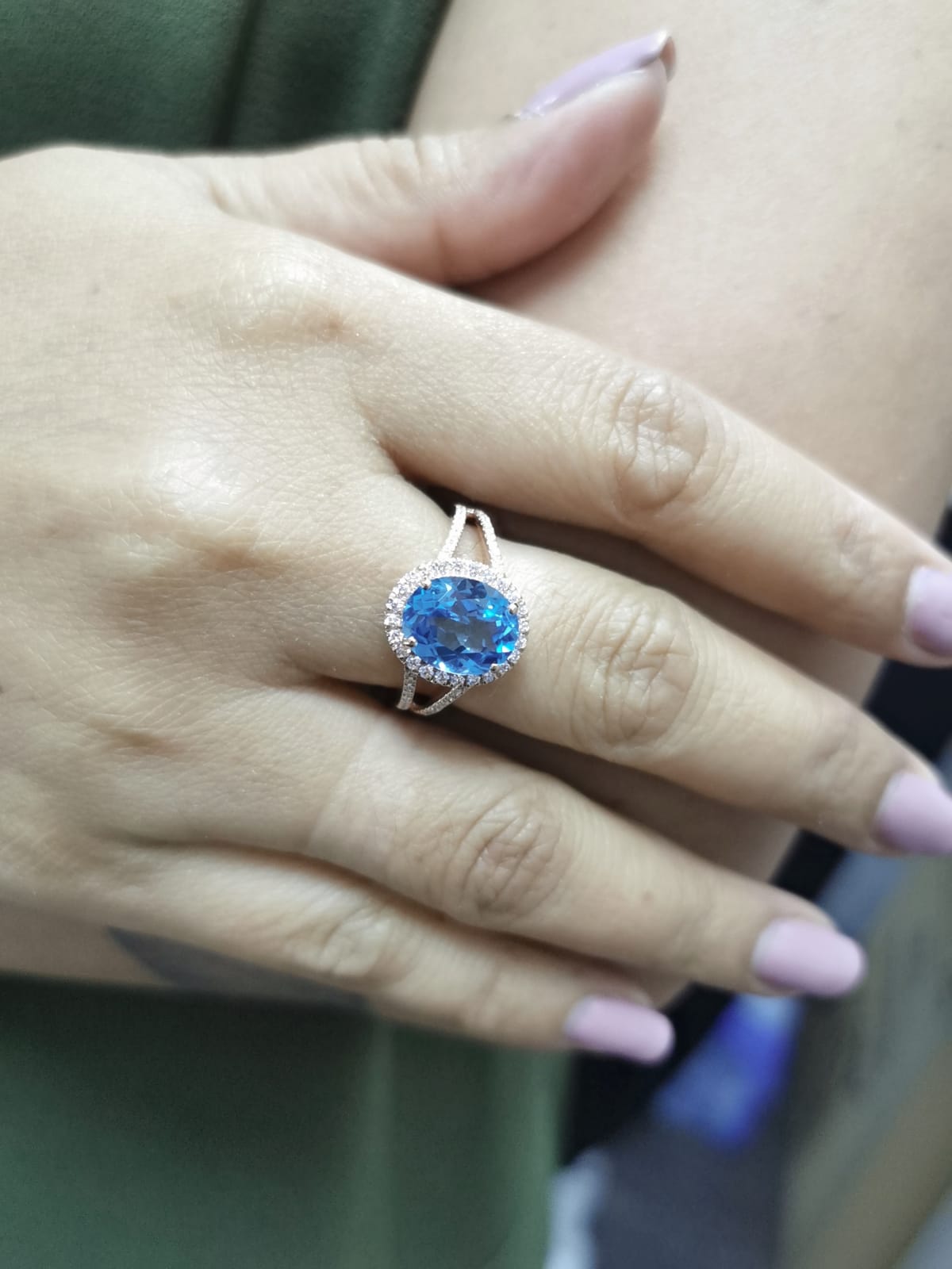 18K rose gold ring with a 4.54 carat oval Swiss Blue Topaz, diamond halo, and diamond-accented split shank design
