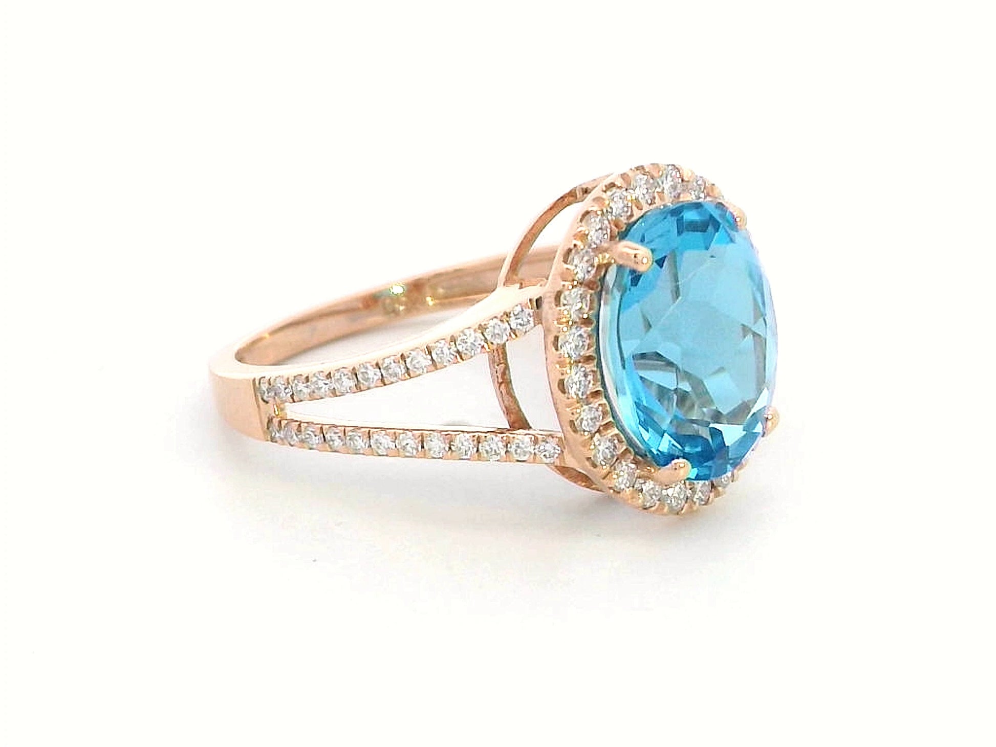 18K rose gold ring with a 4.54 carat oval Swiss Blue Topaz, diamond halo, and diamond-accented split shank design
