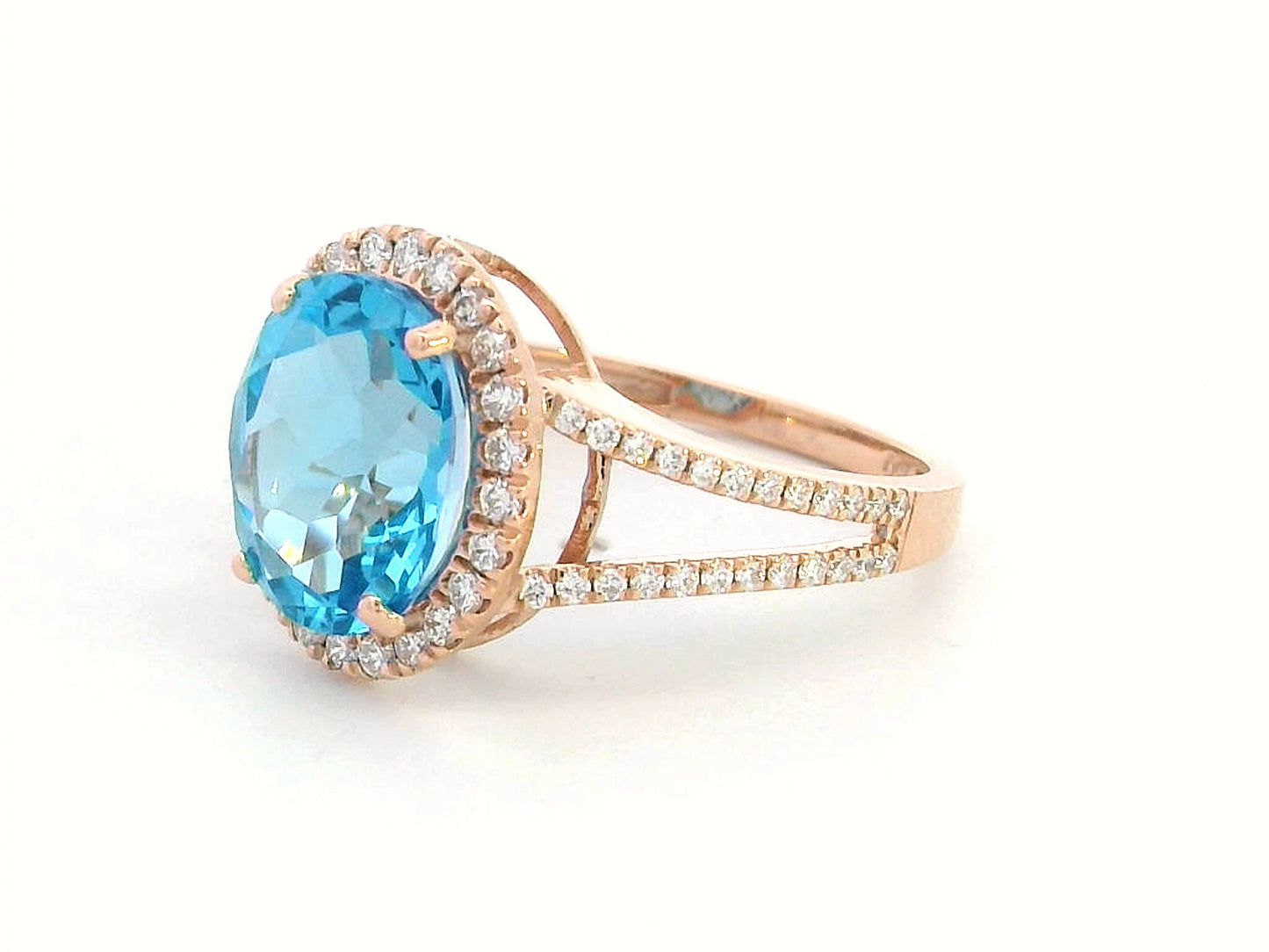 18K rose gold ring with a 4.54 carat oval Swiss Blue Topaz, diamond halo, and diamond-accented split shank design