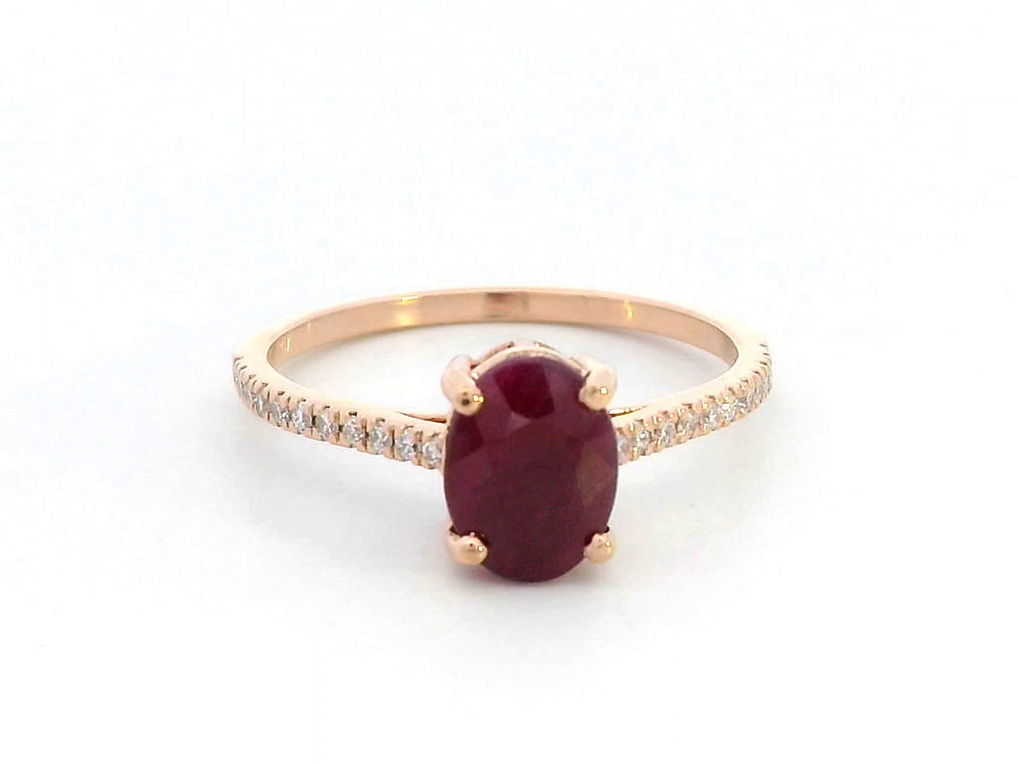18K rose gold ring featuring a 1.92 carat oval-cut ruby with diamond band
