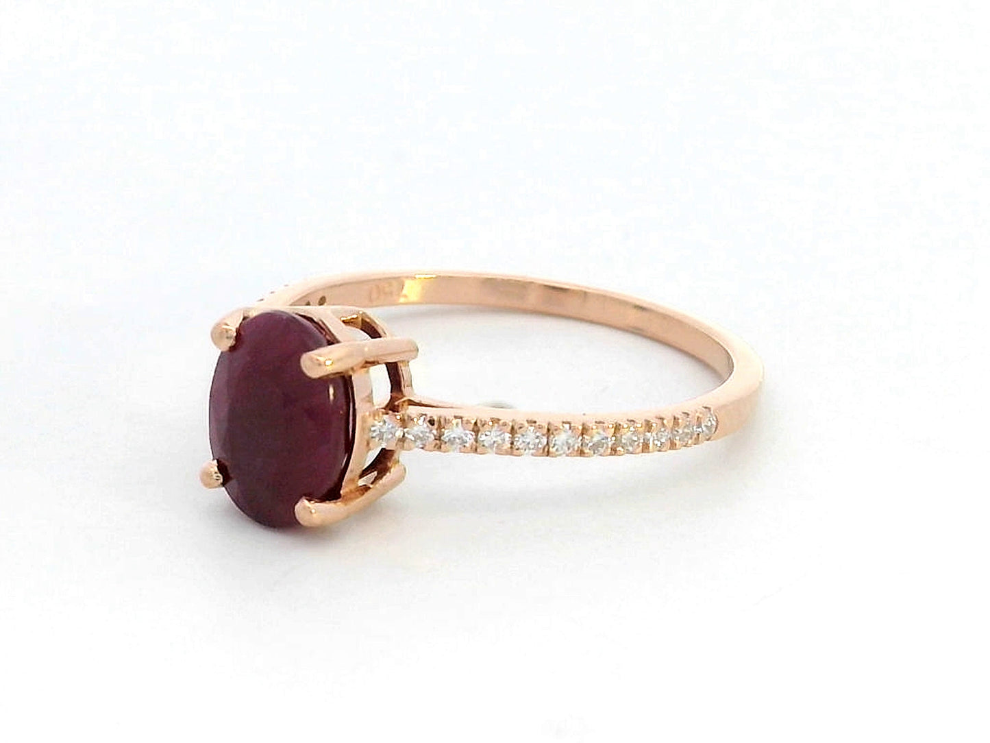 18K rose gold ring featuring a 1.92 carat oval-cut ruby with diamond band