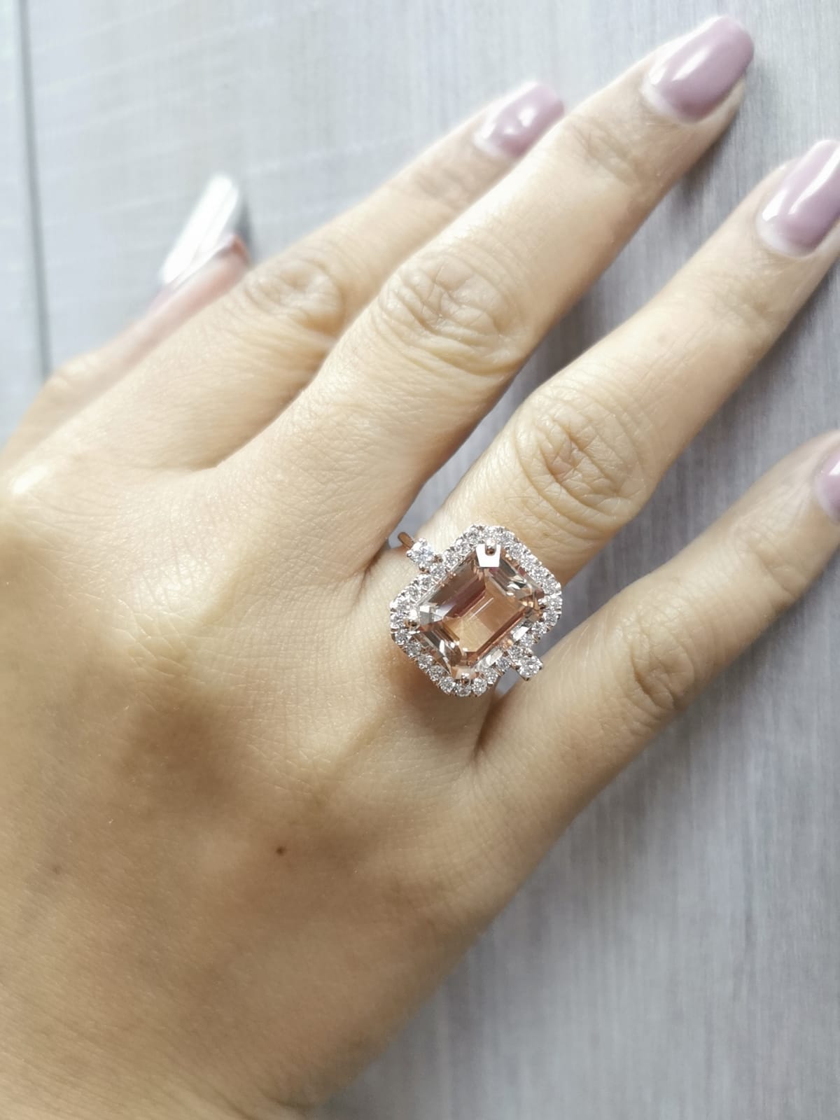 Emerald-cut morganite halo ring with round diamonds in 18K rose gold