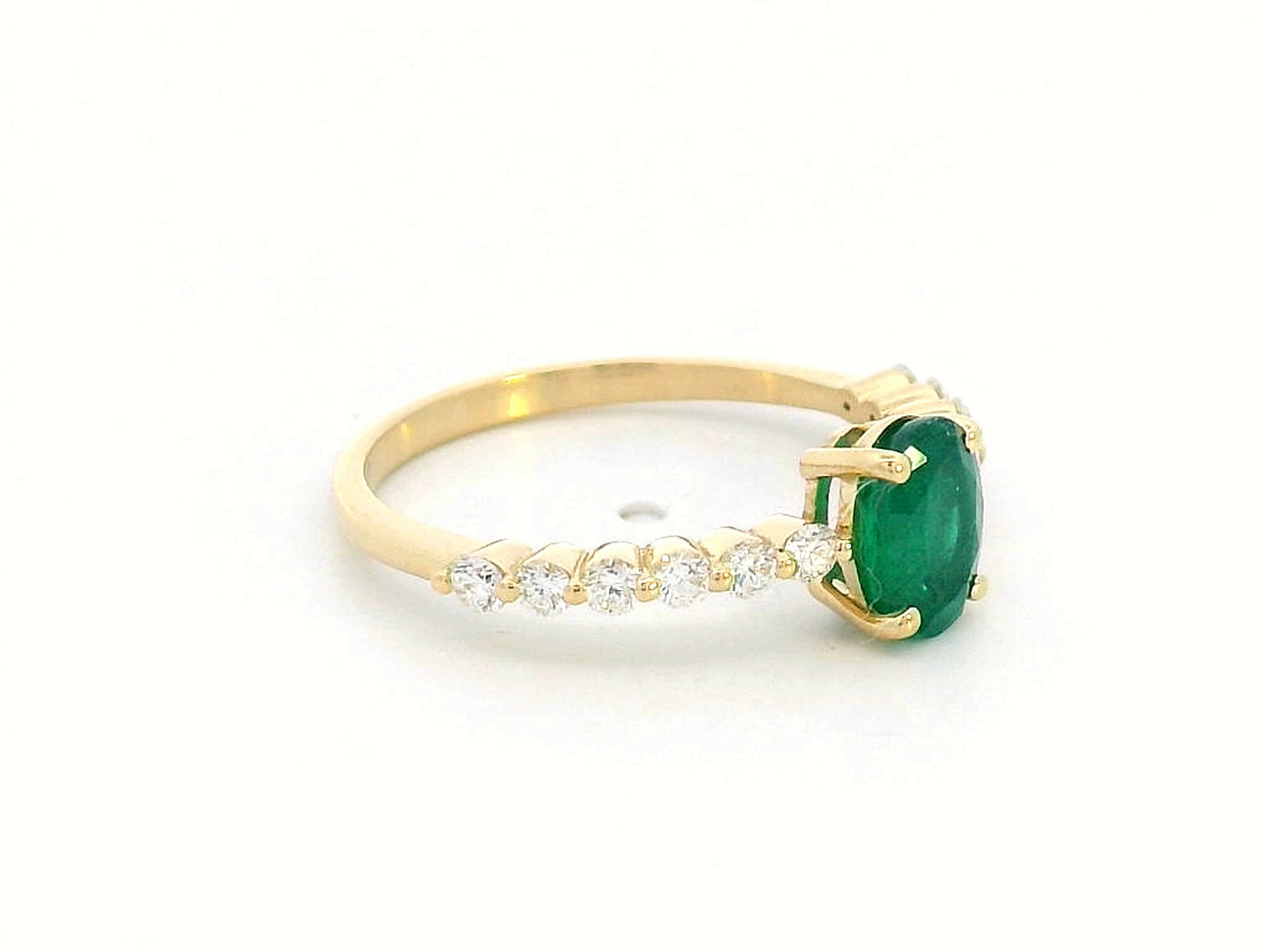 18K yellow gold ring with oval-cut emerald center and round diamond accents on the band