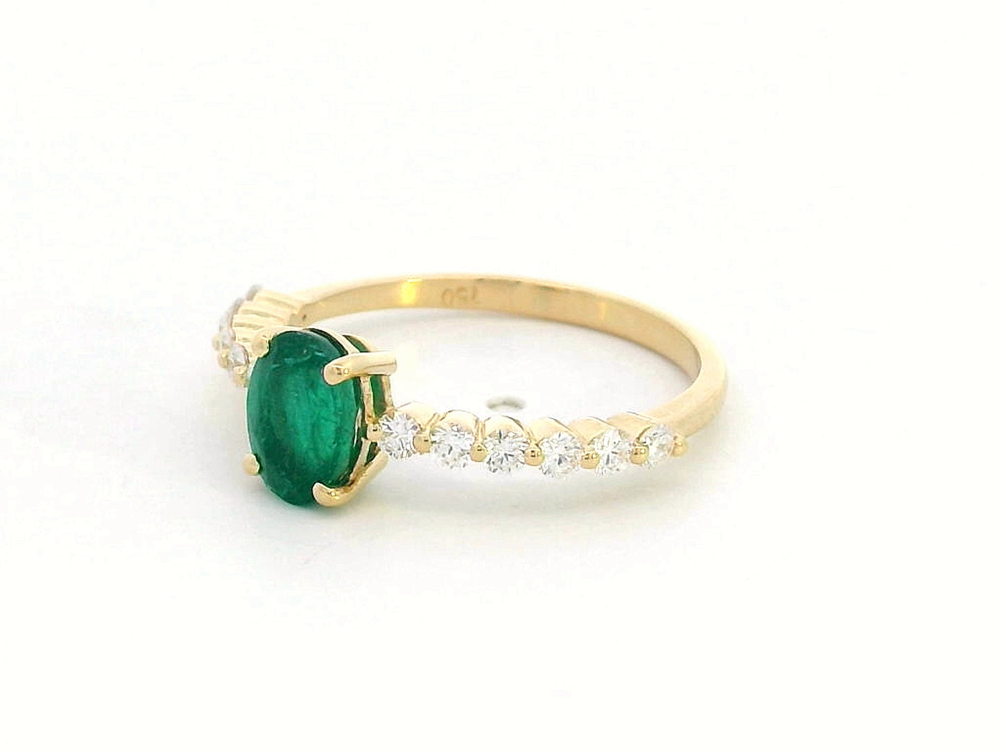 18K yellow gold ring with oval-cut emerald center and round diamond accents on the band