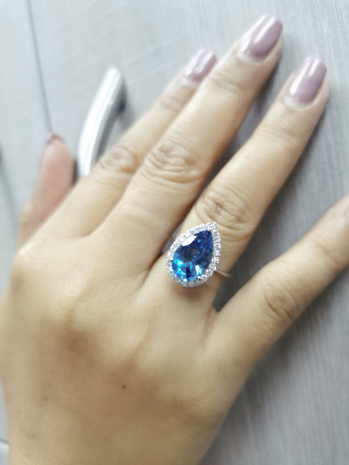 18K white gold ring with 5.26 carat pear-cut London Blue Topaz and diamond halo