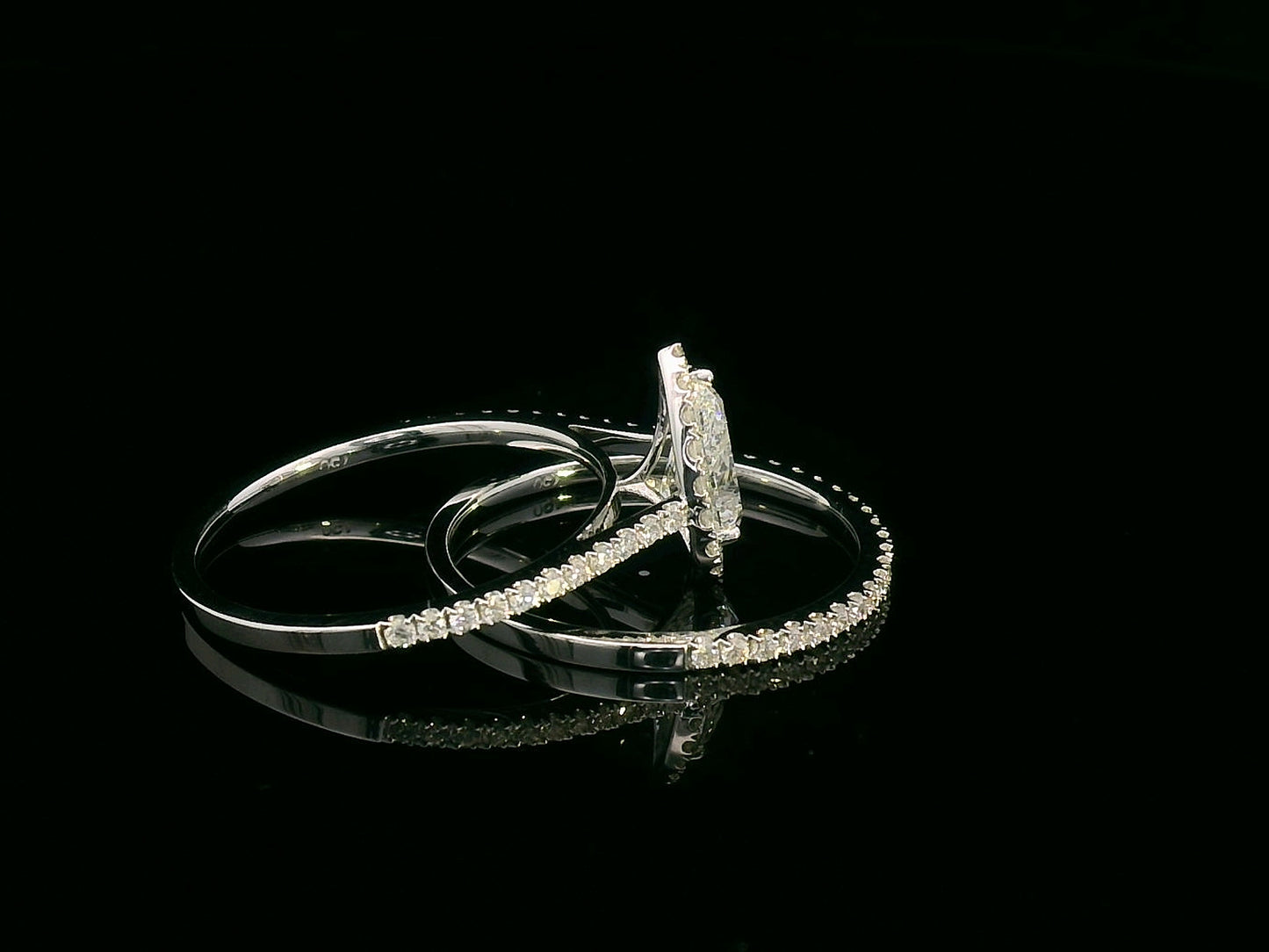18K gold bridal ring set featuring a 0.91 carat pear-shaped diamond with halo and pavé-set accent diamonds on both engagement ring and matching wedding band