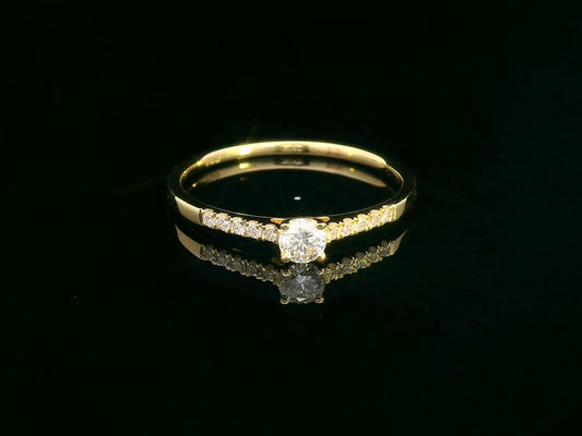 18K yellow gold ring with 0.18ct round center diamond and 10 smaller side diamonds set in a classic straight design.