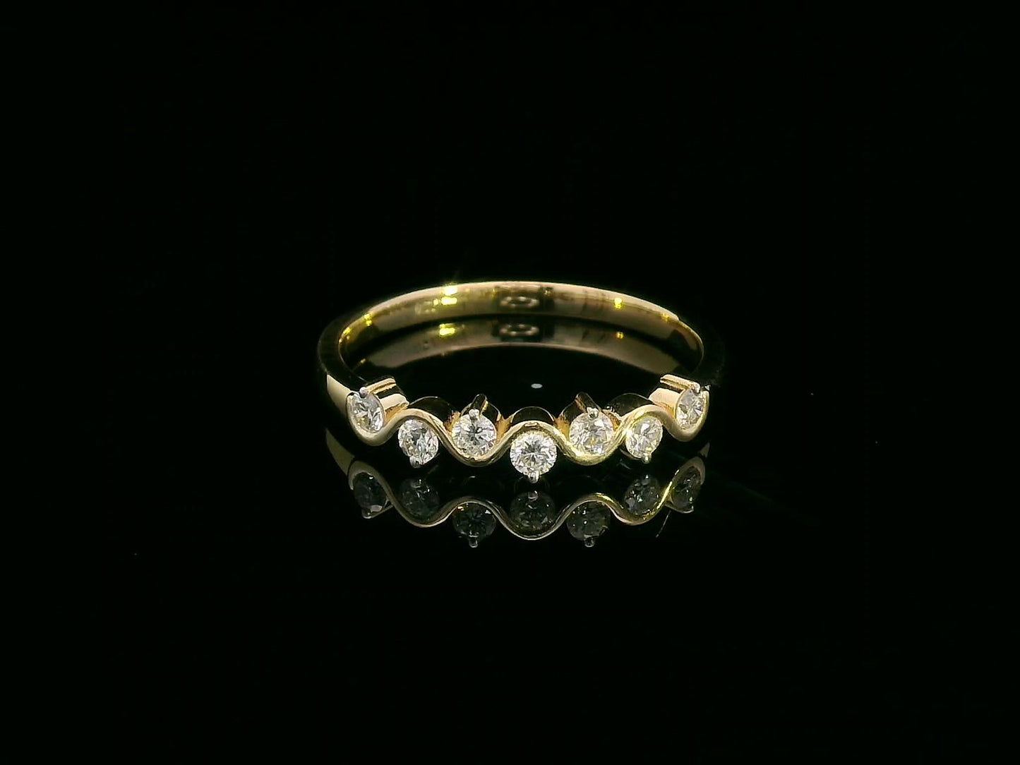 Wave-inspired 18K yellow gold ring with seven round diamonds in a flowing design