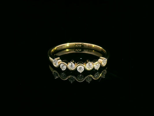 Wave-inspired 18K yellow gold ring with seven round diamonds in a flowing design