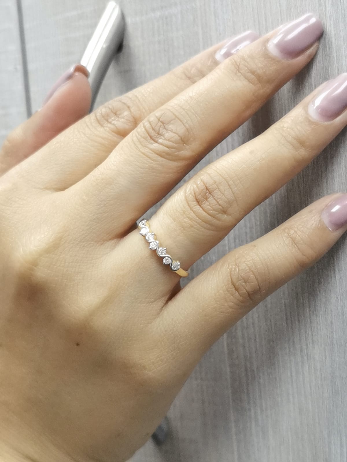 Wave-inspired 18K yellow gold ring with seven round diamonds in a flowing design