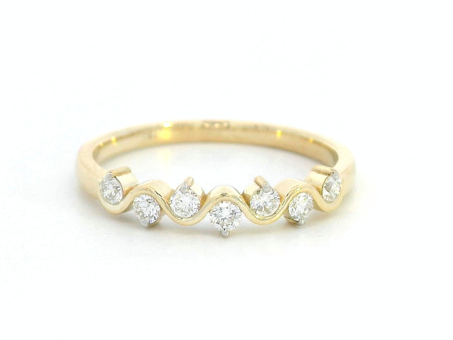 Wave-inspired 18K yellow gold ring with seven round diamonds in a flowing design