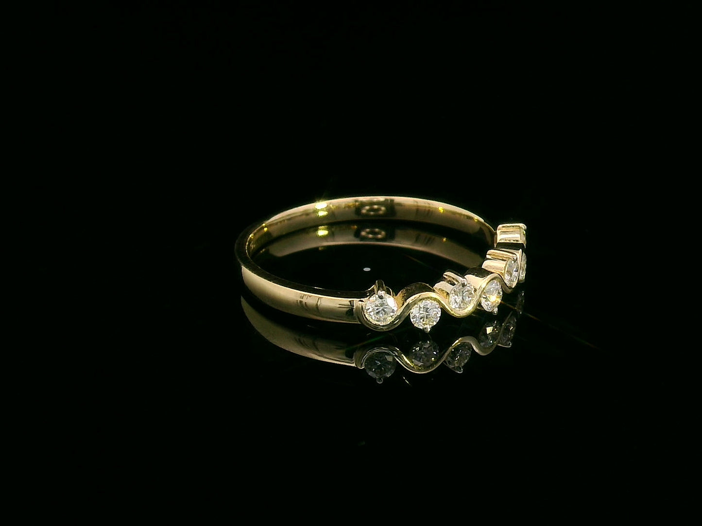 Wave-inspired 18K yellow gold ring with seven round diamonds in a flowing design