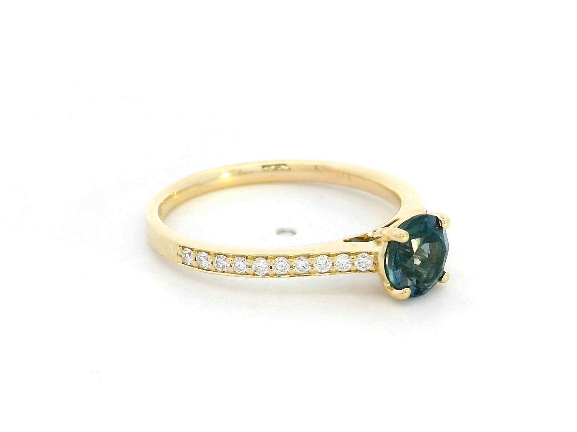 18K yellow gold ring with 0.93 carat round Blue Topaz center and 0.20 carat round diamond accents in fine prong setting along the band