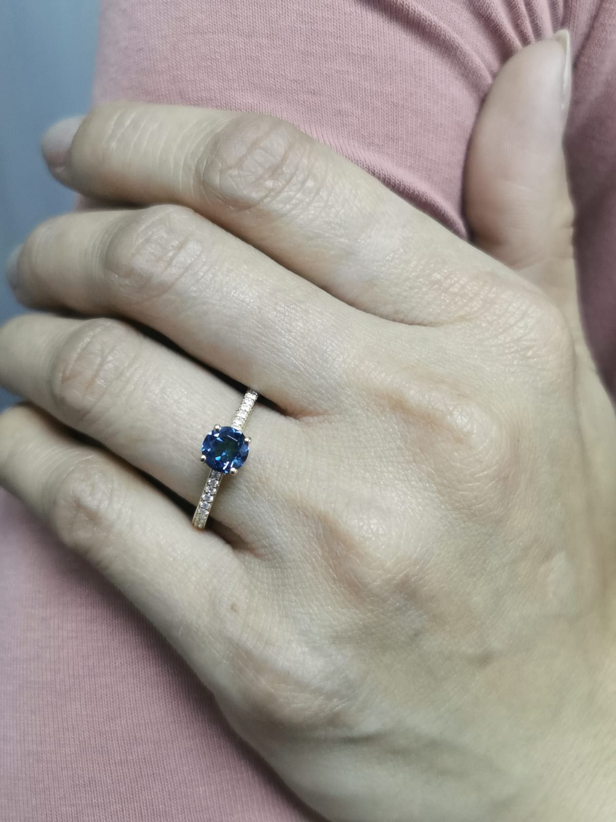 18K yellow gold ring with 0.93 carat round Blue Topaz center and 0.20 carat round diamond accents in fine prong setting along the band