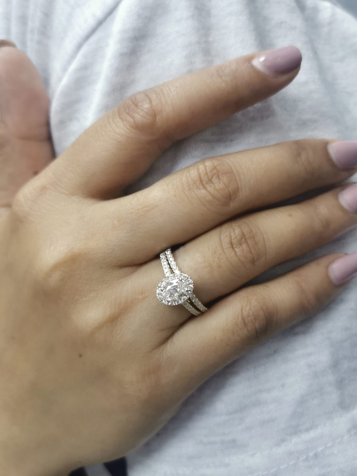 Oval diamond halo bridal set in 18K gold with pavé engagement ring and matching wedding band