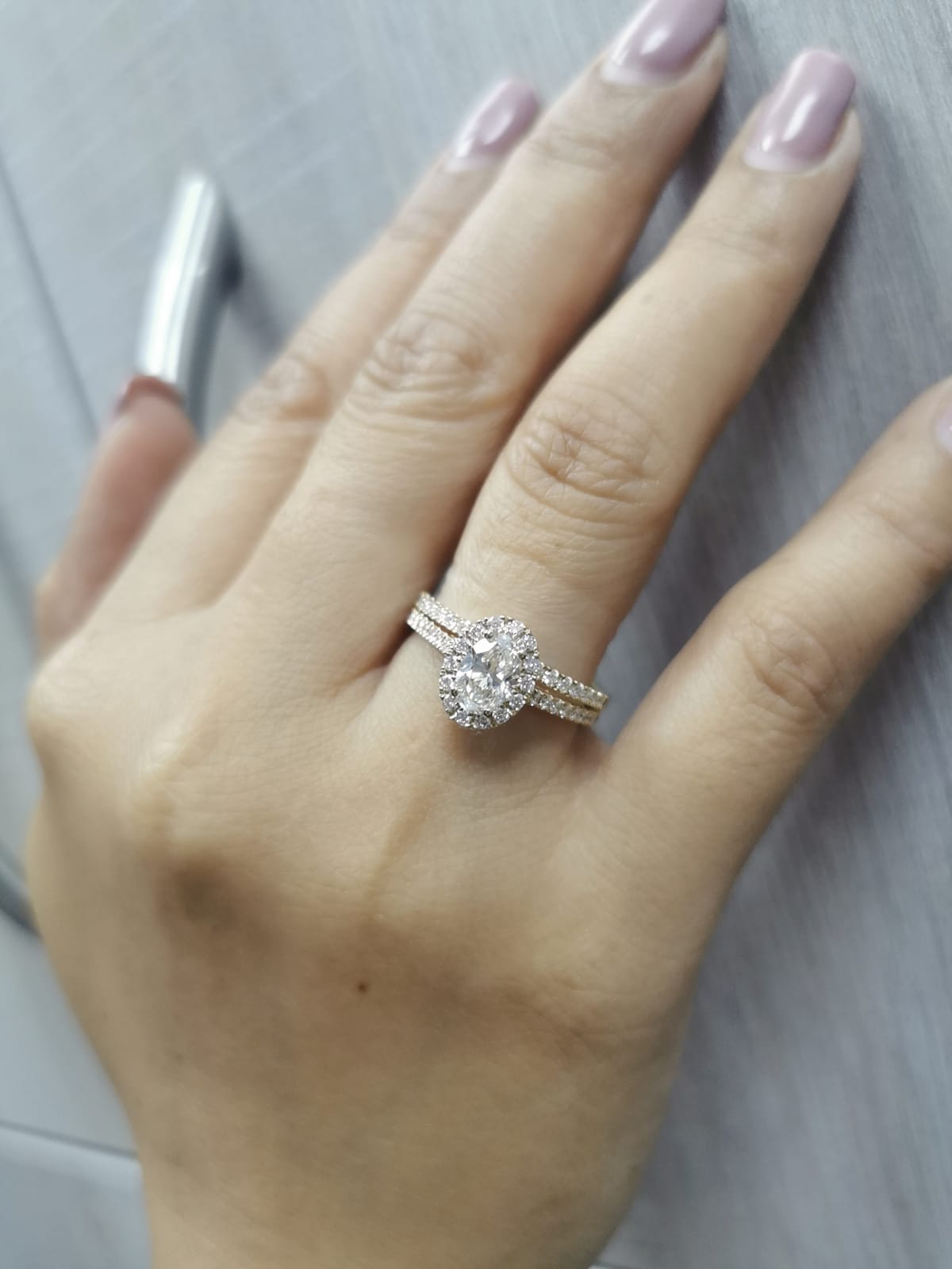 Oval diamond halo bridal set in 18K gold with pavé engagement ring and matching wedding band