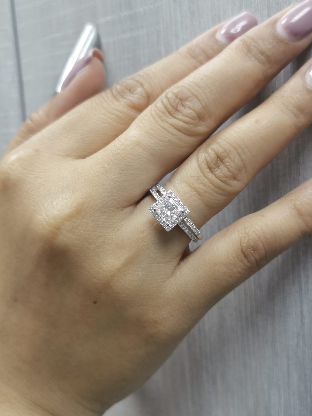 Princess cut diamond halo bridal set in 18K white gold with pavé-set engagement ring and matching band