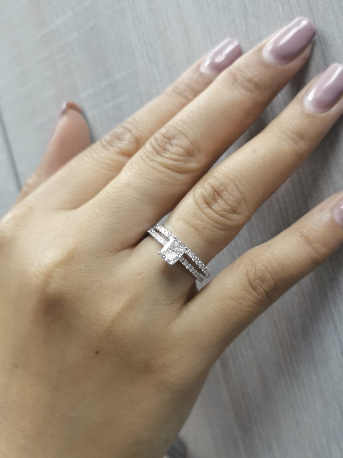 Cushion cut diamond bridal set in 18K white gold featuring pavé engagement ring and matching wedding band