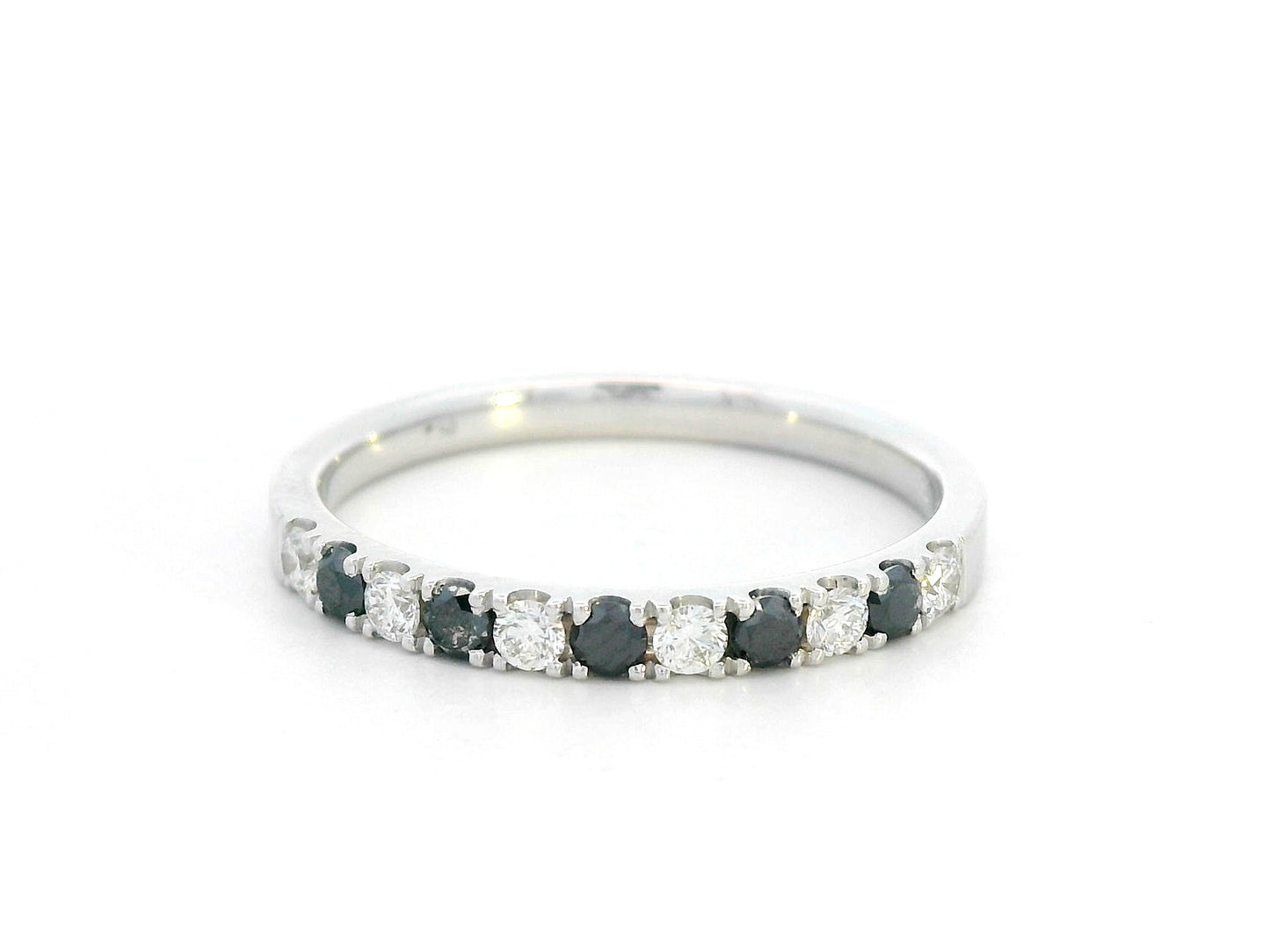 18K gold half eternity ring with alternating black and white round diamonds, minimalist band design.