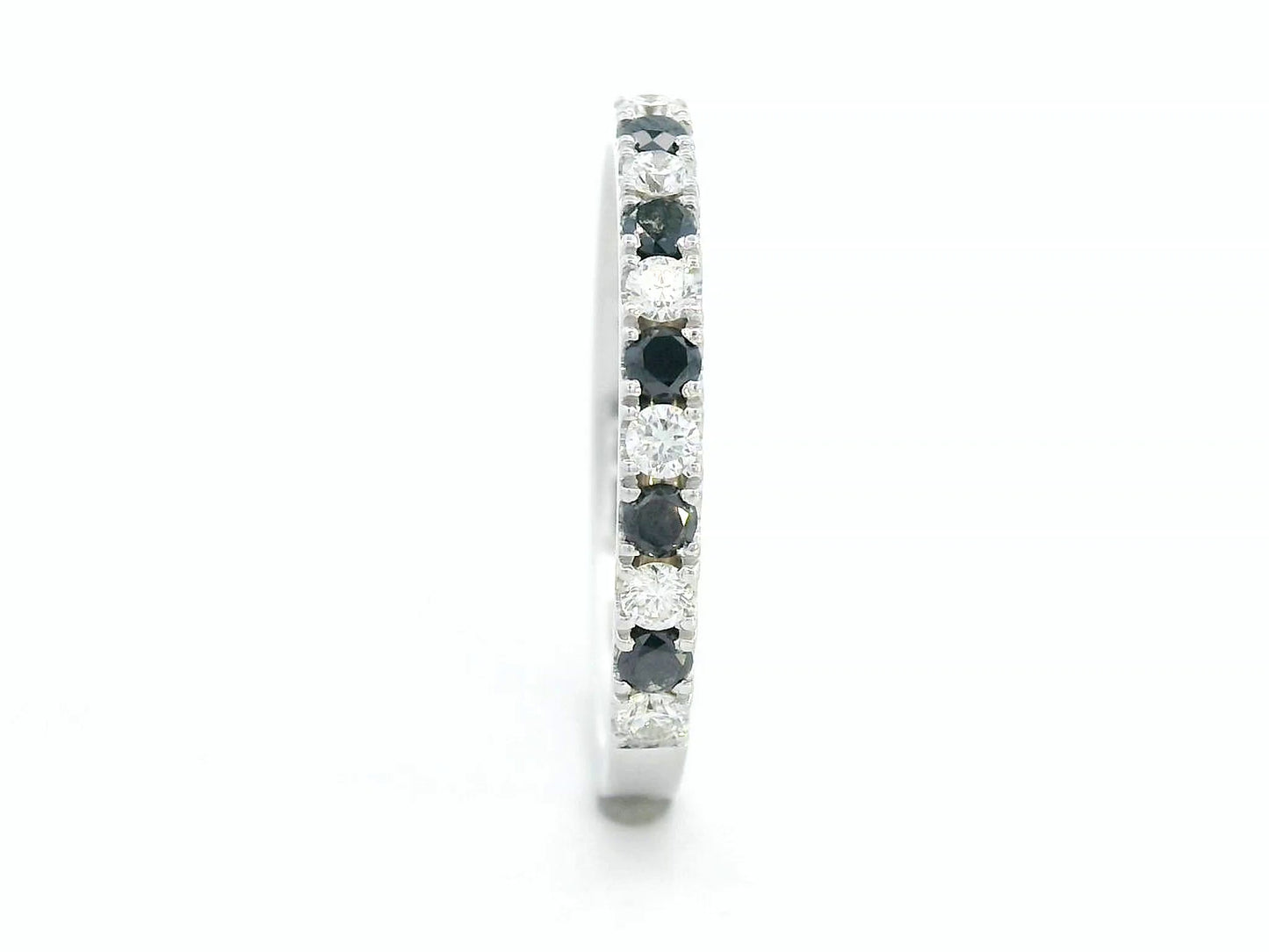18K gold half eternity ring with alternating black and white round diamonds, minimalist band design.