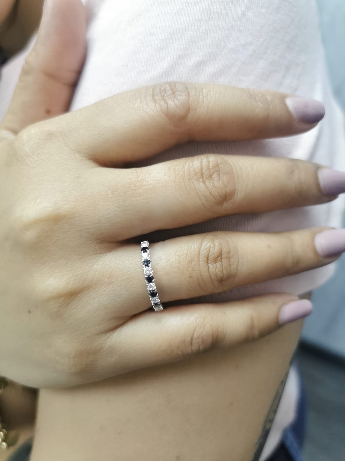 18K gold half eternity ring with alternating black and white round diamonds, minimalist band design.