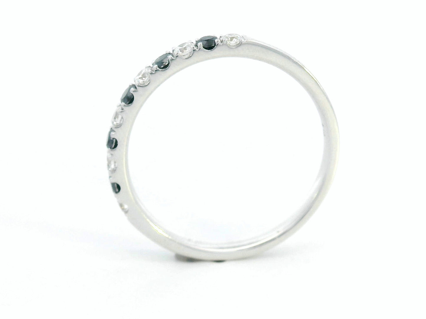 18K gold half eternity ring with alternating black and white round diamonds, minimalist band design.