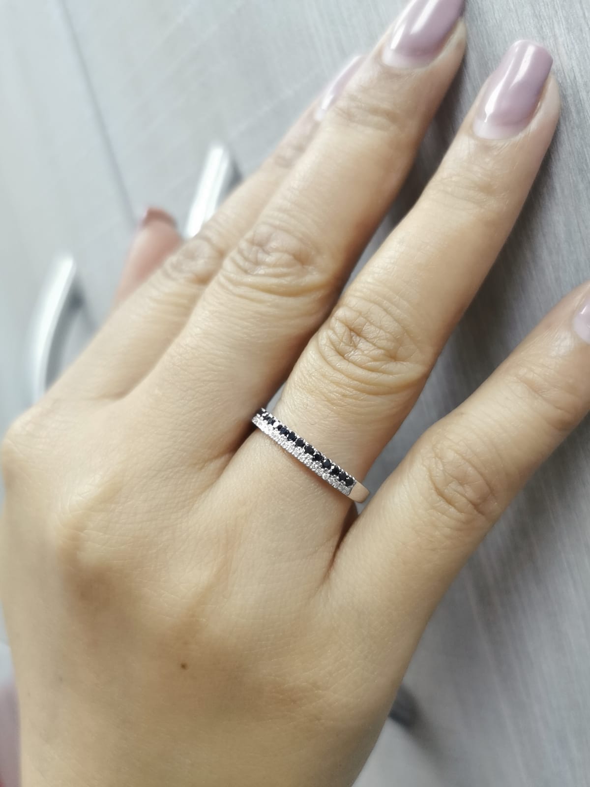 18K white gold ring with parallel rows of white and black diamonds in a modern half eternity band design.