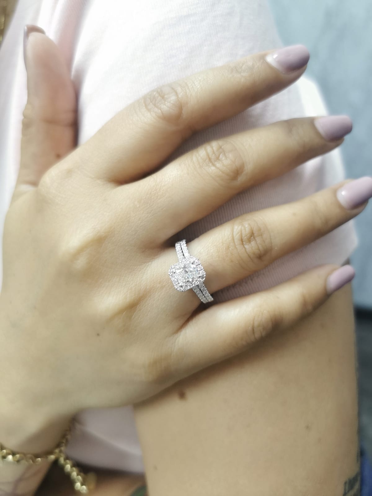 18K white gold bridal ring set with 1.50ct radiant-cut diamond, halo setting, pavé band, and matching half-eternity wedding band.