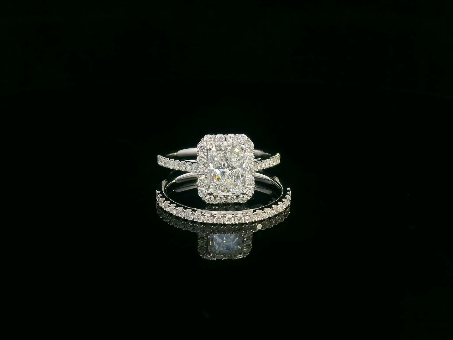 18K white gold bridal ring set with 1.50ct radiant-cut diamond, halo setting, pavé band, and matching half-eternity wedding band.