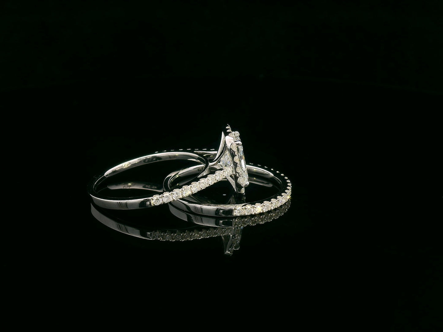 18K white gold bridal ring set with 1.50ct radiant-cut diamond, halo setting, pavé band, and matching half-eternity wedding band.