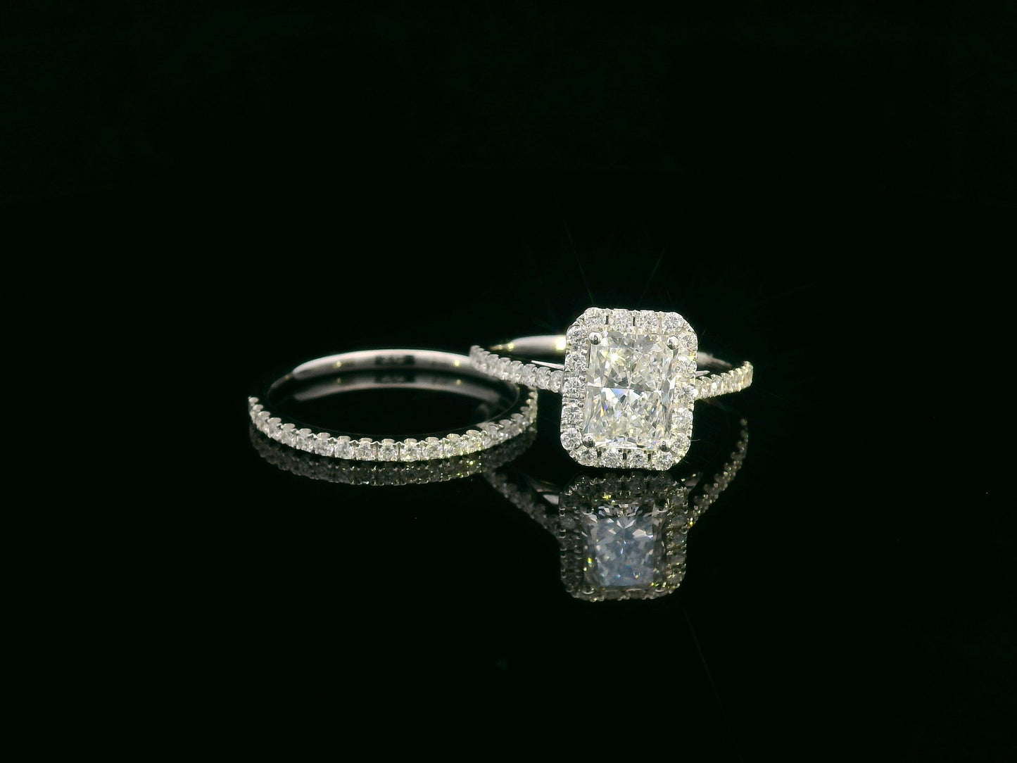18K white gold bridal ring set with 1.50ct radiant-cut diamond, halo setting, pavé band, and matching half-eternity wedding band.