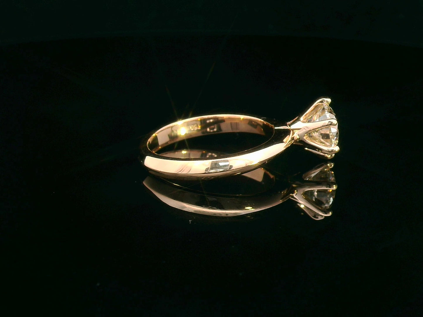 Side profile of rose gold diamond engagement ring showing six-prong setting and band design