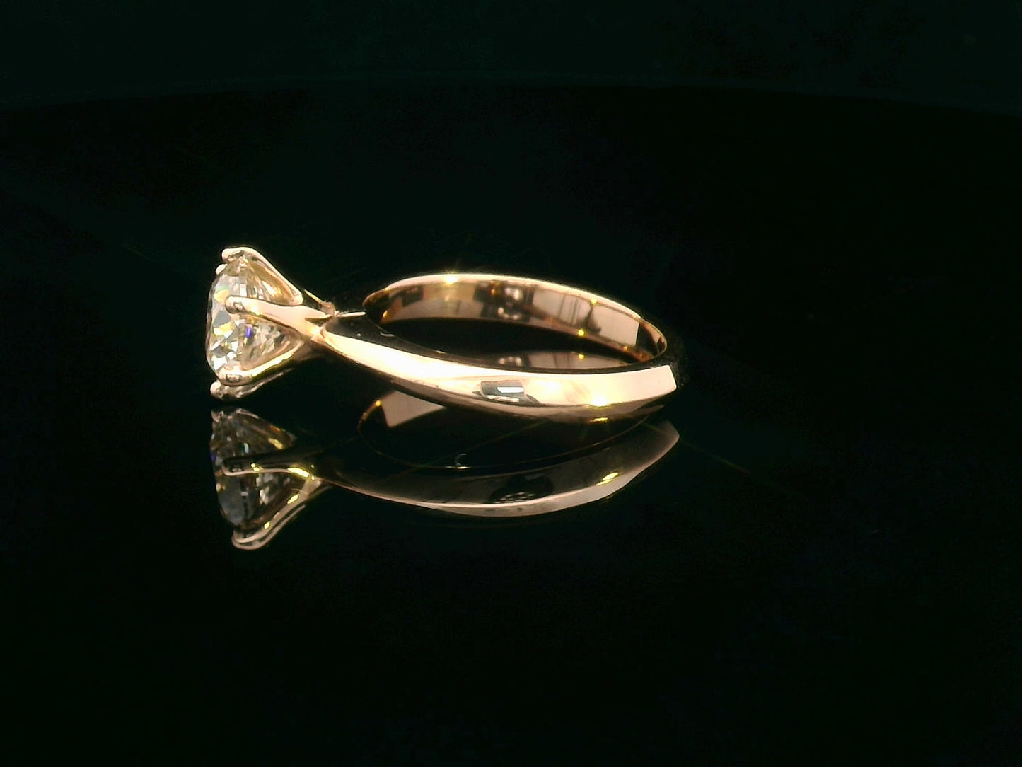 Side profile of rose gold diamond engagement ring showing six-prong setting and band design