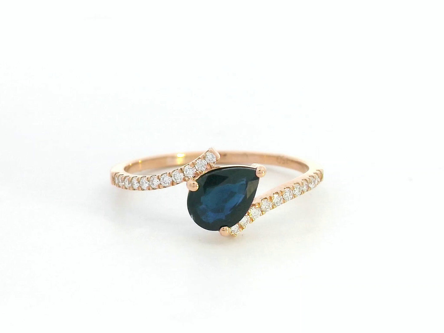 18K rose gold ring with pear-shaped blue sapphire and pavé diamond band