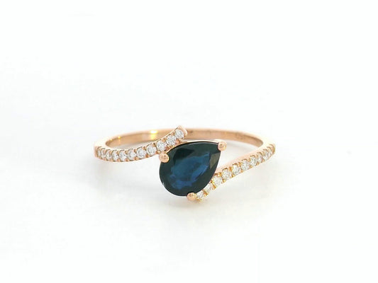 18K rose gold ring with pear-shaped blue sapphire and pavé diamond band