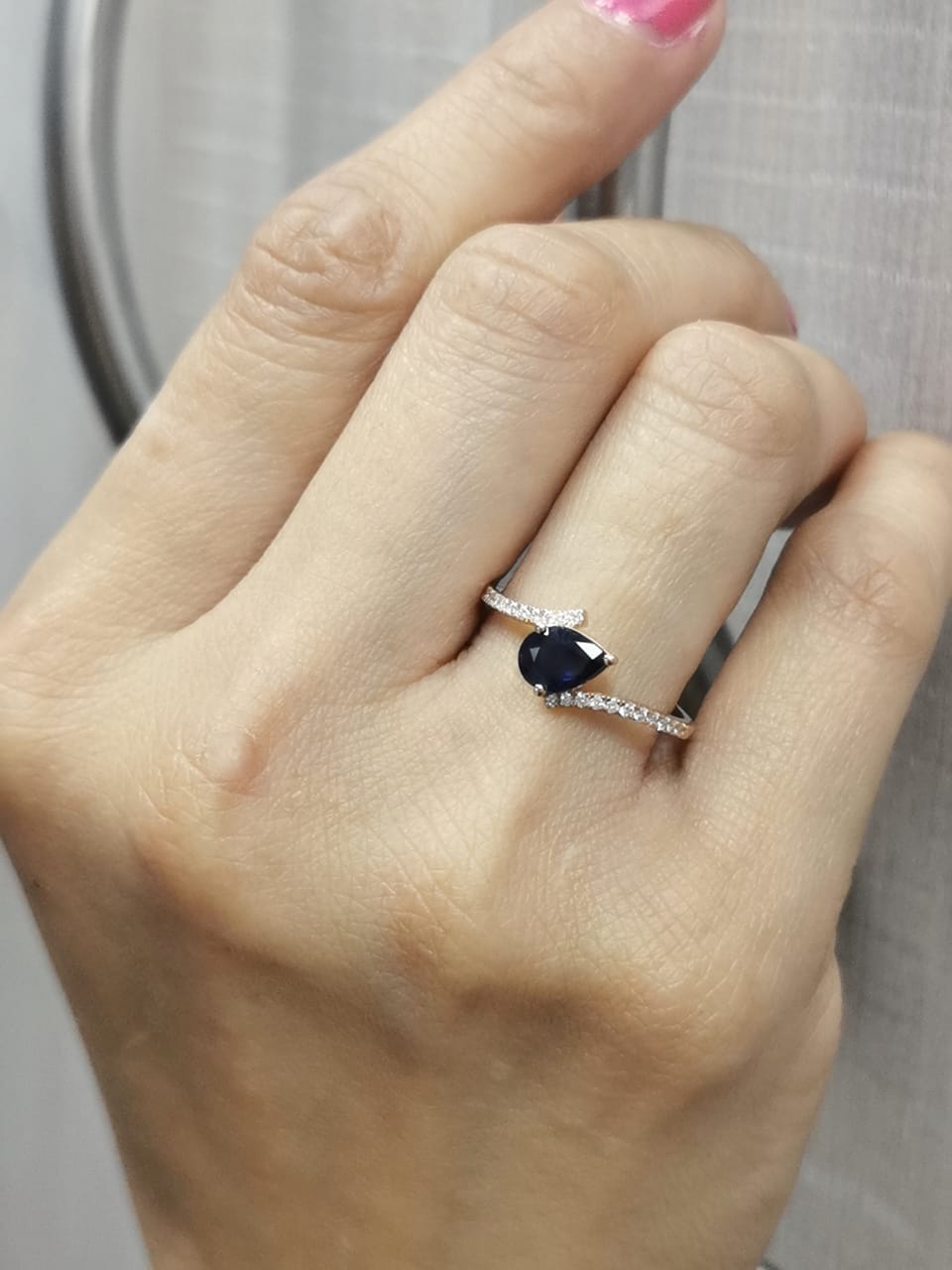 18K rose gold ring with pear-shaped blue sapphire and pavé diamond band