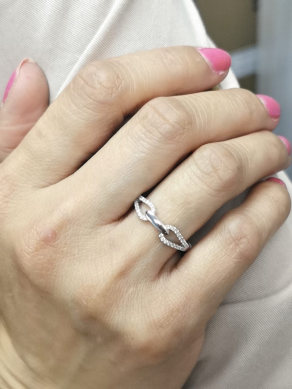 18K white gold double loop diamond ring with central polished link and 0.21 carats of diamonds