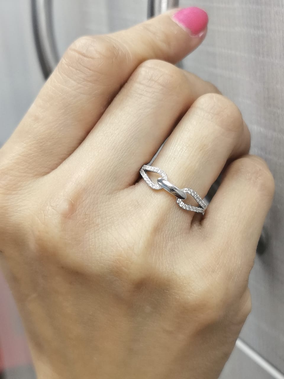18K white gold double loop diamond ring with central polished link and 0.21 carats of diamonds