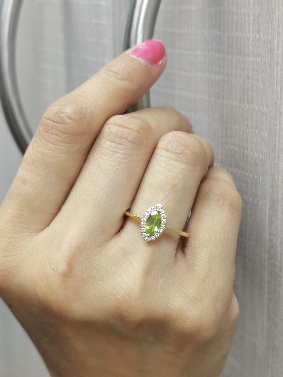 18k yellow gold ring featuring a 0.64ct marquise Peridot surrounded by a 0.15ct diamond
