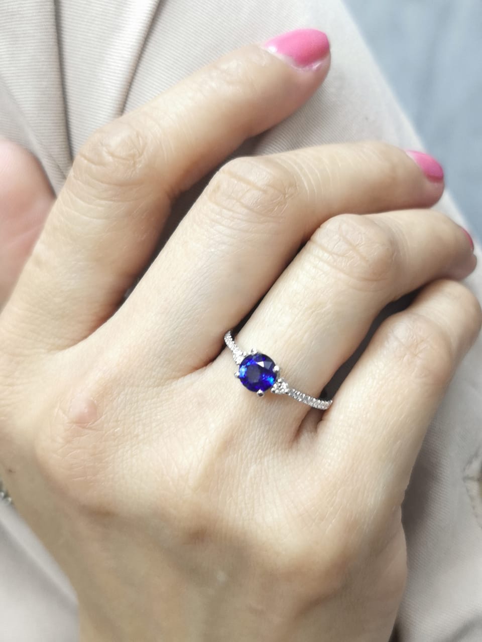 Blue sapphire ring in 18K white gold with flanking diamonds and pavé diamond band