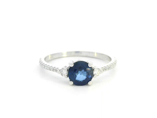 Blue sapphire ring in 18K white gold with flanking diamonds and pavé diamond band