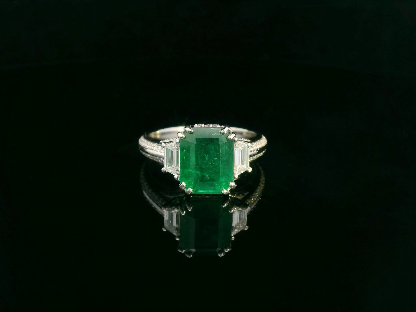 Emerald and diamond ring with trapezoid and round accent diamonds set in 18K gold – 3.05ct center emerald