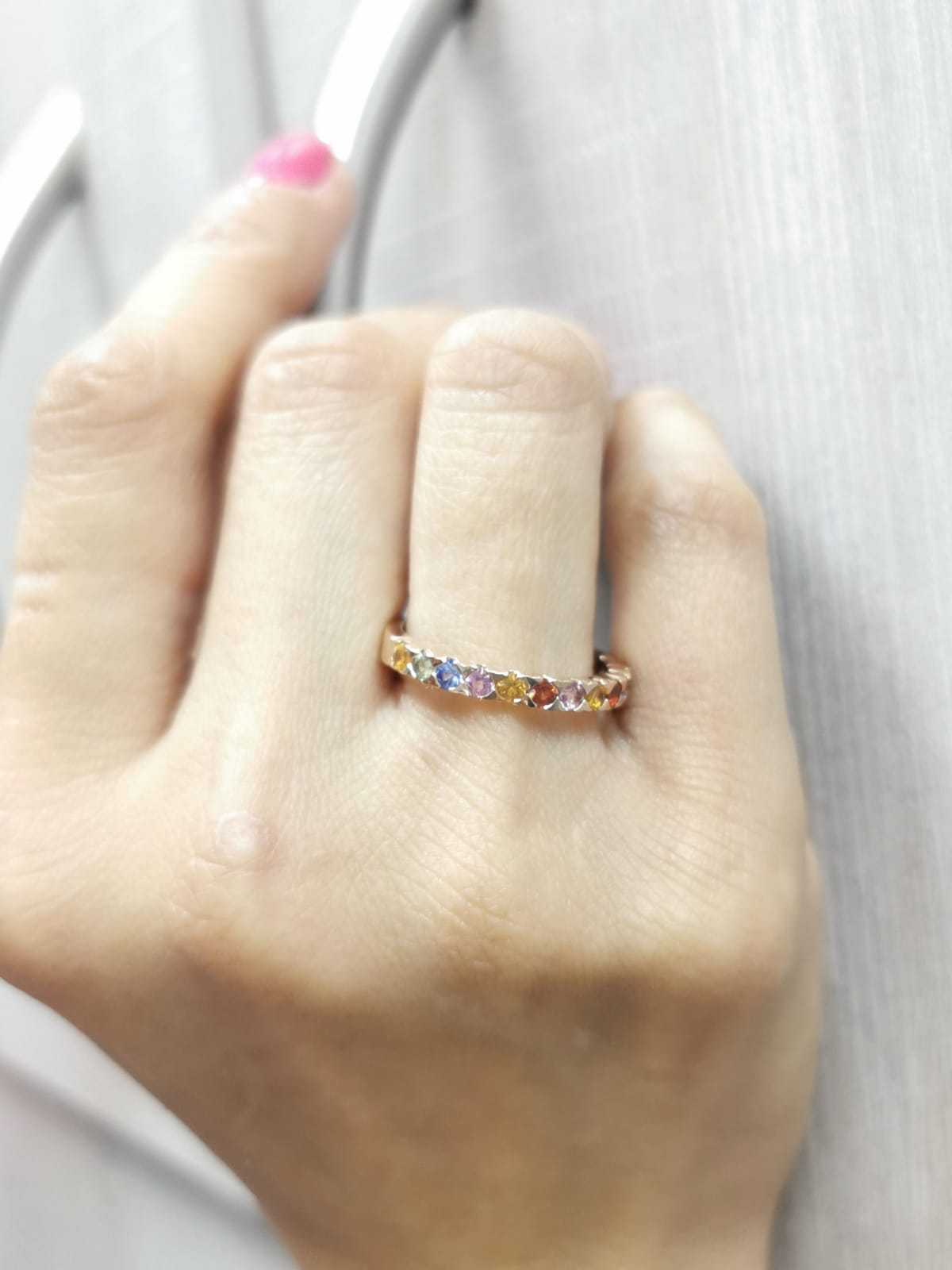 18K rose gold ring set with 0.93 carats of multicolored round sapphires in a half band design